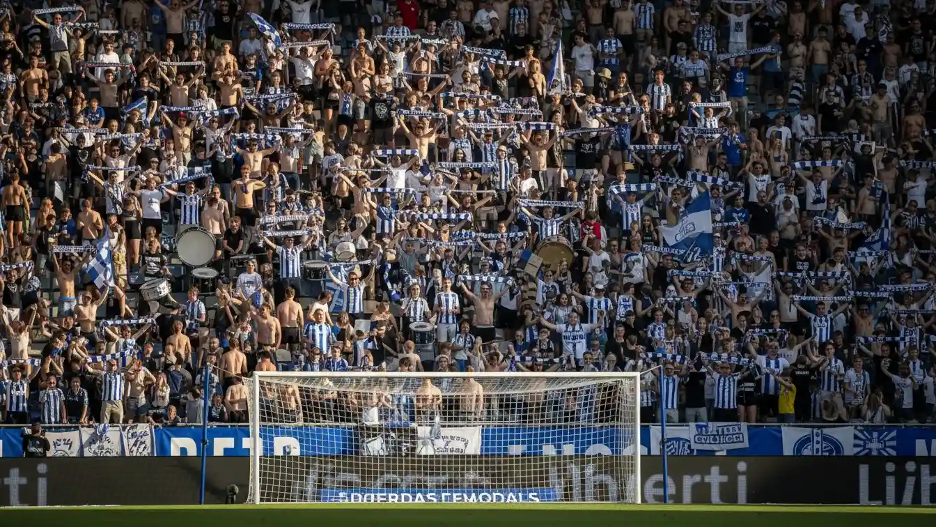Fans på nordtribunen synger og støtter holdet